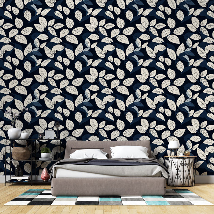 Une chambre moderne avec un papier peint aux motifs de feuilles blanches et bleues sur fond bleu marine, créant une ambiance apaisante et élégante.