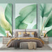 Une chambre moderne avec un papier peint représentant de grandes feuilles vertes et dorées, créant une atmosphère apaisante et naturelle.