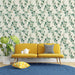 Un salon lumineux avec un papier peint floral aux motifs de feuilles vertes sur fond clair, créant une ambiance naturelle et apaisante.