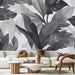 Un salon contemporain avec un papier peint noir et blanc représentant de grandes feuilles stylisées, créant une atmosphère élégante et apaisante.
