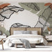 Une chambre apaisante avec un papier peint représentant de grandes feuilles stylisées en noir et vert, créant une atmosphère naturelle et contemporaine.