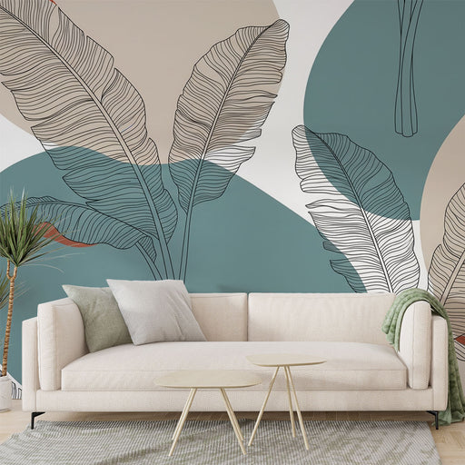 Un salon moderne avec un papier peint tropical aux grandes feuilles stylisées sur fond bleu-vert et beige, créant une atmosphère fraîche et apaisante.