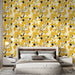 Une chambre contemporaine avec un papier peint floral aux motifs de feuilles jaunes et noires sur fond crème, créant une atmosphère chaleureuse et accueillante.