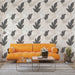 Une pièce moderne avec un papier peint aux motifs de feuilles stylisées en noir et gris sur fond clair, créant une ambiance élégante et apaisante.