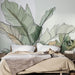 Une chambre moderne avec un papier peint représentant de grandes feuilles aux lignes épurées et aux teintes douces, créant une atmosphère apaisante et naturelle.