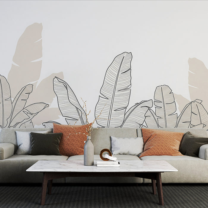 Un salon moderne avec un papier peint représentant de grandes feuilles tropicales en noir sur un fond beige, créant une ambiance apaisante et naturelle.