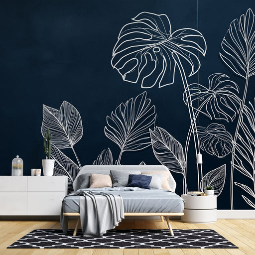 Une chambre moderne avec un papier peint bleu nuit orné de feuilles blanches stylisées, créant une ambiance élégante et apaisante.