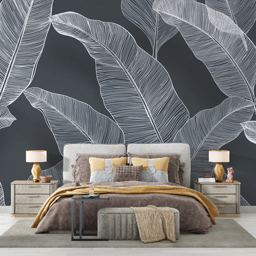 Une chambre élégante avec un papier peint représentant de grandes feuilles blanches sur fond noir, créant une atmosphère moderne et apaisante.