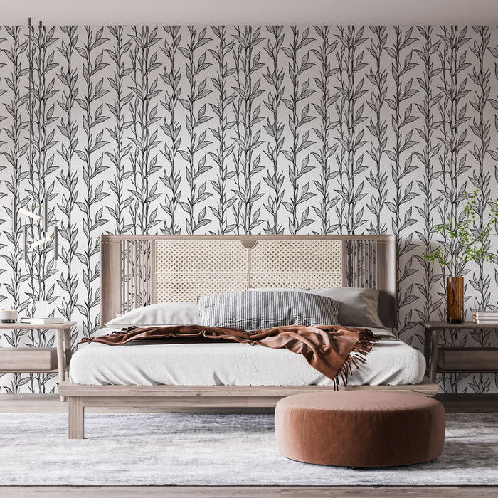 Une chambre élégante avec un papier peint aux motifs de feuilles noires sur fond blanc, créant une atmosphère apaisante et naturelle.