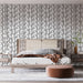 Une chambre élégante avec un papier peint aux motifs de feuilles noires sur fond blanc, créant une atmosphère apaisante et naturelle.