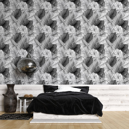 Une chambre moderne avec un papier peint monochrome représentant des feuilles stylisées, créant une ambiance élégante et apaisante.