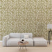Un salon moderne avec un papier peint aux motifs de feuilles blanches sur fond vert olive, créant une atmosphère apaisante et naturelle.