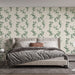 Une chambre moderne avec un papier peint floral aux motifs de feuilles vertes sur fond crème, créant une atmosphère apaisante et naturelle.