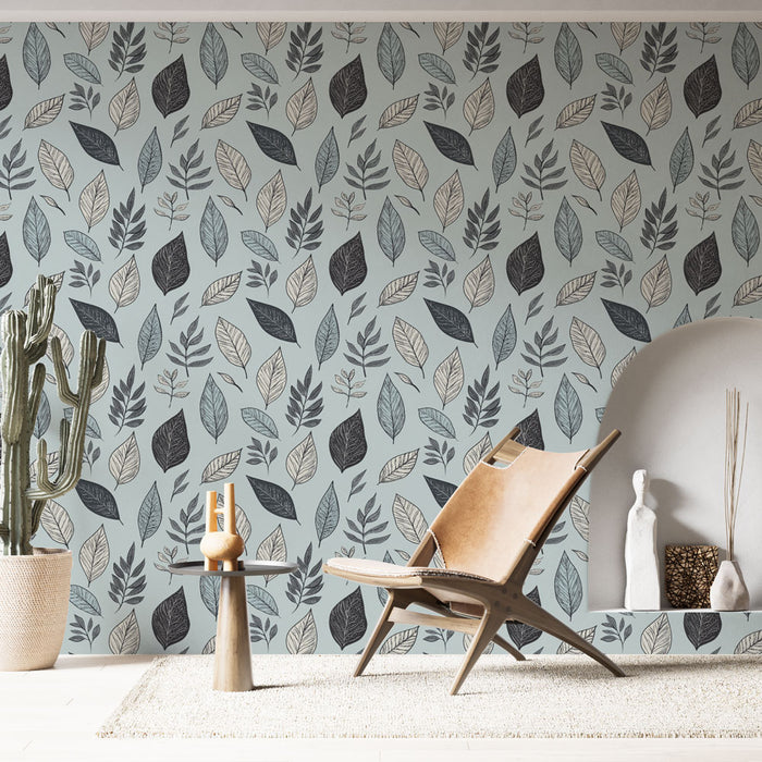 Une pièce lumineuse avec un papier peint aux motifs de feuilles stylisées dans des teintes de bleu, noir et beige, créant une ambiance naturelle et apaisante.
