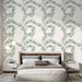 Une chambre moderne avec un papier peint floral aux motifs de couronnes de feuillage vert et bleu sur fond clair, créant une ambiance fraîche et apaisante.