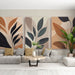 Un salon moderne avec un papier peint abstrait aux motifs de feuilles dans des teintes chaudes et naturelles, créant une ambiance chaleureuse et accueillante.