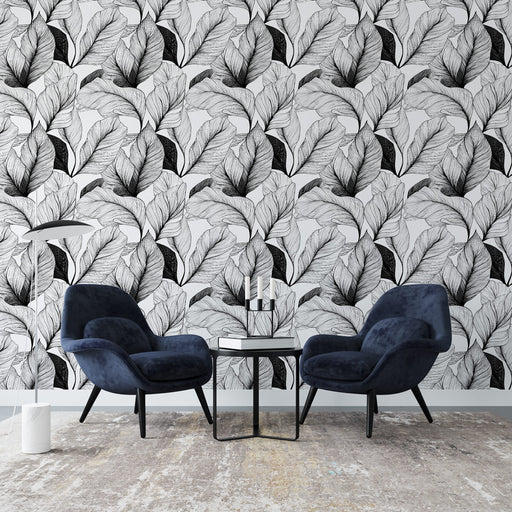 Un salon moderne avec un papier peint monochrome représentant des feuilles délicates en noir et blanc, créant une atmosphère élégante et artistique.