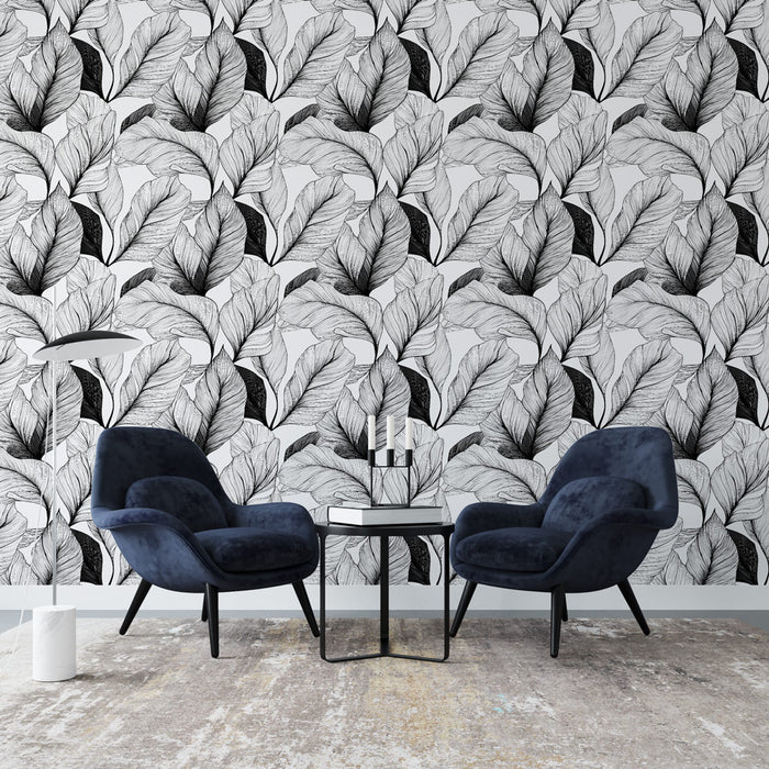 Un salon moderne avec un papier peint monochrome représentant des feuilles délicates en noir et blanc, créant une atmosphère élégante et artistique.