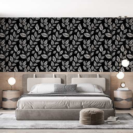 Une chambre moderne avec un papier peint noir orné de motifs de feuilles blanches, créant une ambiance élégante et sophistiquée.