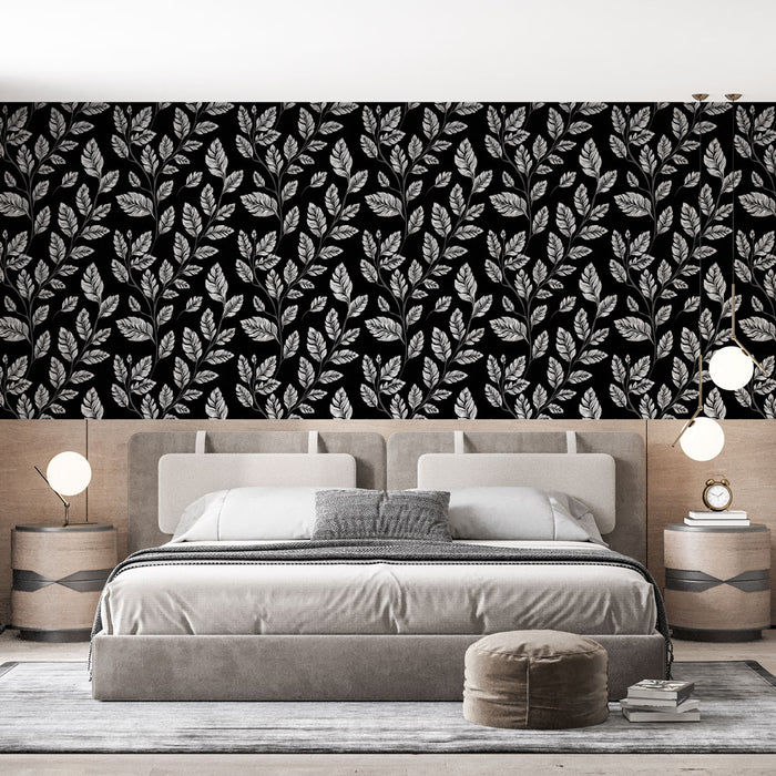 Une chambre moderne avec un papier peint noir orné de motifs de feuilles blanches, créant une ambiance élégante et sophistiquée.