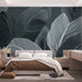 Une chambre moderne avec un papier peint représentant de grandes feuilles stylisées en blanc sur fond gris, créant une atmosphère apaisante et élégante.