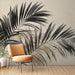 Une pièce moderne avec un papier peint représentant de grandes feuilles de palmier noires sur fond beige, créant une ambiance élégante et apaisante.