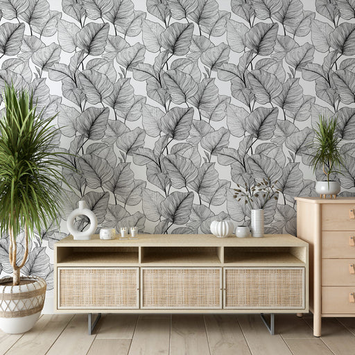 Un salon moderne avec un papier peint représentant des feuilles délicates en noir et blanc, créant une ambiance élégante et apaisante.