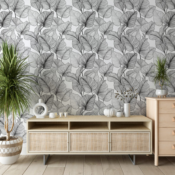 Un salon moderne avec un papier peint représentant des feuilles délicates en noir et blanc, créant une ambiance élégante et apaisante.