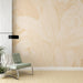 Une pièce moderne avec un papier peint aux motifs de grandes feuilles délicates dans des teintes beige et doré, créant une ambiance apaisante et naturelle.