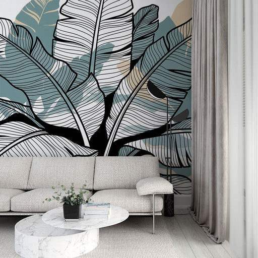 Un salon contemporain avec un papier peint tropical aux grandes feuilles stylisées en noir et vert, créant une ambiance fraîche et apaisante.