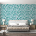Une chambre moderne avec un papier peint aux motifs de feuilles turquoise sur fond clair, créant une atmosphère fraîche et apaisante.