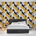 Une chambre moderne avec un papier peint aux motifs de grandes feuilles jaunes et noires sur fond blanc, créant une ambiance dynamique et élégante.