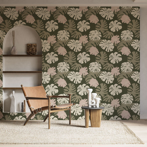 Une pièce moderne avec un papier peint tropical aux grandes feuilles vertes et des touches de rose sur fond olive, créant une ambiance chaleureuse et accueillante.