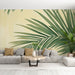 Un salon moderne avec un papier peint tropical aux grandes feuilles vertes sur fond jaune, créant une ambiance fraîche et apaisante.
