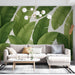 Un salon moderne avec un papier peint tropical représentant de grandes feuilles vertes sur fond clair, créant une ambiance fraîche et naturelle.