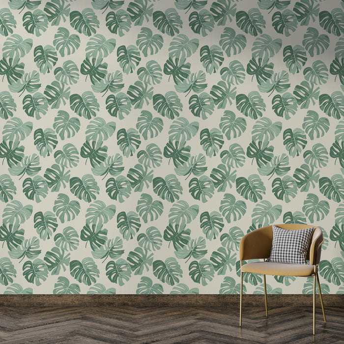 Une pièce moderne avec un papier peint tropical aux feuilles de monstera vertes sur fond clair, évoquant une atmosphère fraîche et accueillante.