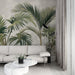 Un salon moderne avec un papier peint tropical représentant de grandes feuilles de palmier sur un fond doux, créant une atmosphère apaisante et naturelle.