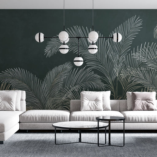 Un salon moderne avec un papier peint vert foncé orné de grandes feuilles de palmier blanches, créant une ambiance tropicale et élégante.