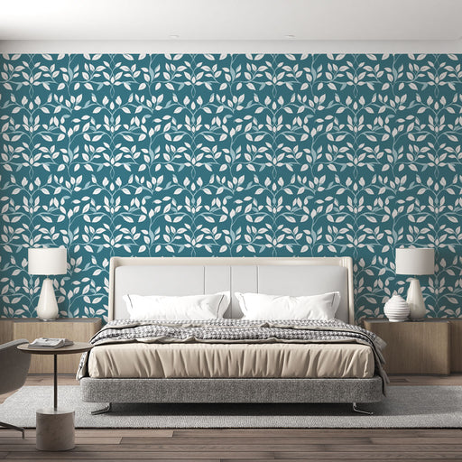 Une chambre moderne avec un papier peint bleu canard orné de motifs de feuilles blanches, créant une atmosphère apaisante et naturelle.