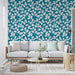 Un salon moderne avec un papier peint aux motifs de feuilles blanches sur fond turquoise, créant une ambiance fraîche et vivifiante.