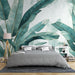 Une chambre apaisante avec un papier peint tropical représentant de grandes feuilles vertes sur fond clair, créant une atmosphère naturelle et relaxante.