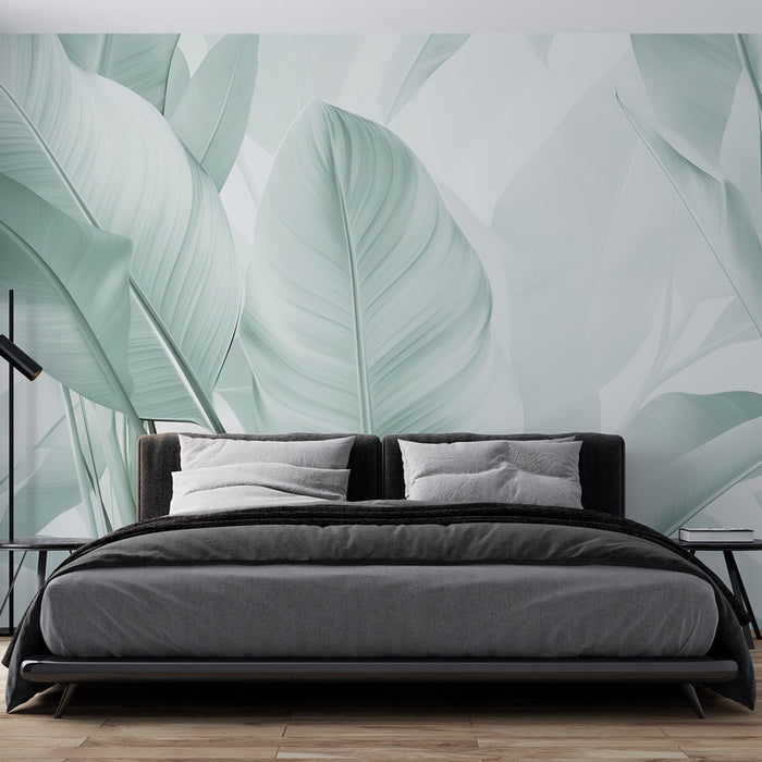 Une chambre moderne avec un papier peint tropical aux grandes feuilles vertes claires sur fond doux, créant une ambiance apaisante et naturelle.