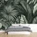 Une chambre moderne avec un papier peint tropical en nuances de vert représentant des feuilles exotiques détaillées, créant une atmosphère apaisante et naturelle.
