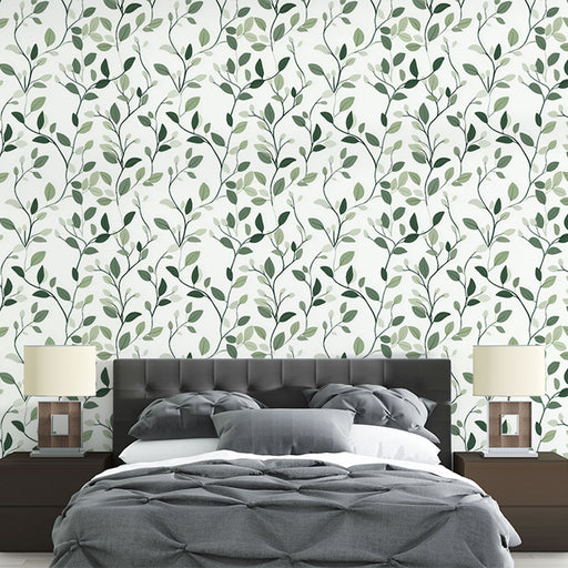 Une chambre élégante avec un papier peint aux motifs de feuillage vert sur fond blanc, créant une atmosphère apaisante et naturelle.