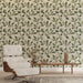 Une pièce élégante avec un papier peint floral aux motifs de feuilles vertes sur fond beige, créant une atmosphère naturelle et apaisante.
