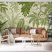 Un salon lumineux avec un papier peint tropical aux motifs de feuilles vertes sur fond clair, créant une atmosphère fraîche et apaisante.