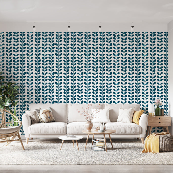 Un salon lumineux avec un papier peint à motifs de feuilles stylisées bleu marine sur fond blanc, créant une ambiance fraîche et moderne.