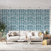 Un salon lumineux avec un papier peint à motifs de feuilles stylisées bleu marine sur fond blanc, créant une ambiance fraîche et moderne.