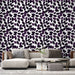 Un salon élégant avec un papier peint aux motifs de feuilles violettes sur fond blanc, créant une atmosphère à la fois moderne et apaisante.
