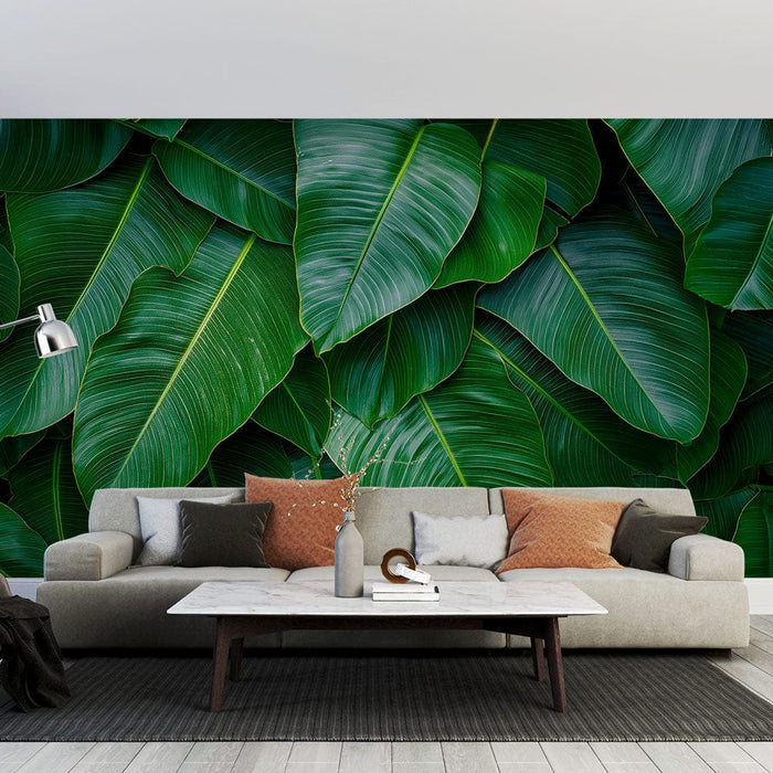 Un salon moderne avec un papier peint tropical représentant de grandes feuilles vertes luxuriantes créant une ambiance naturelle et apaisante.